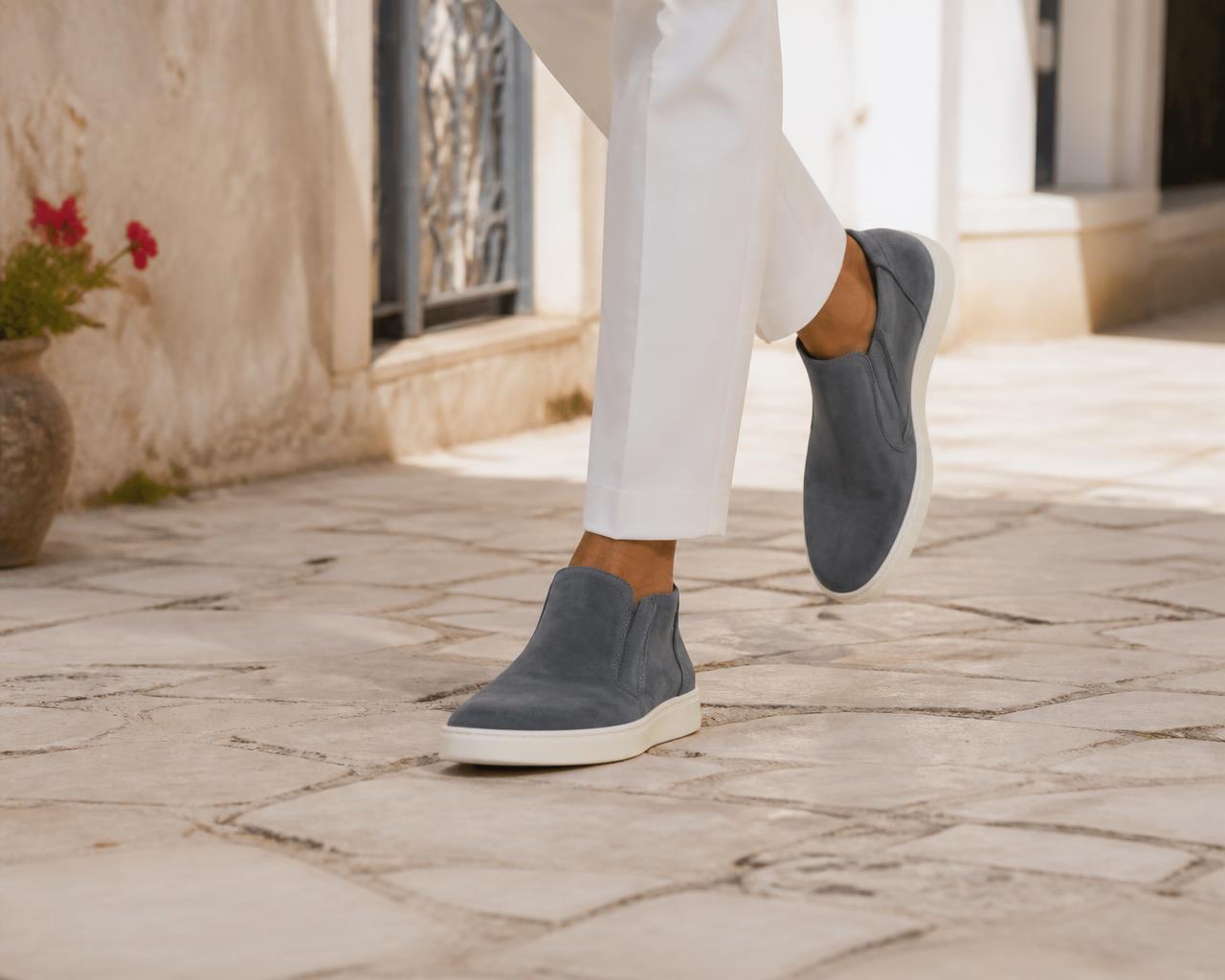 The Capri Loafer worn with white trousers on Mediterranean stone