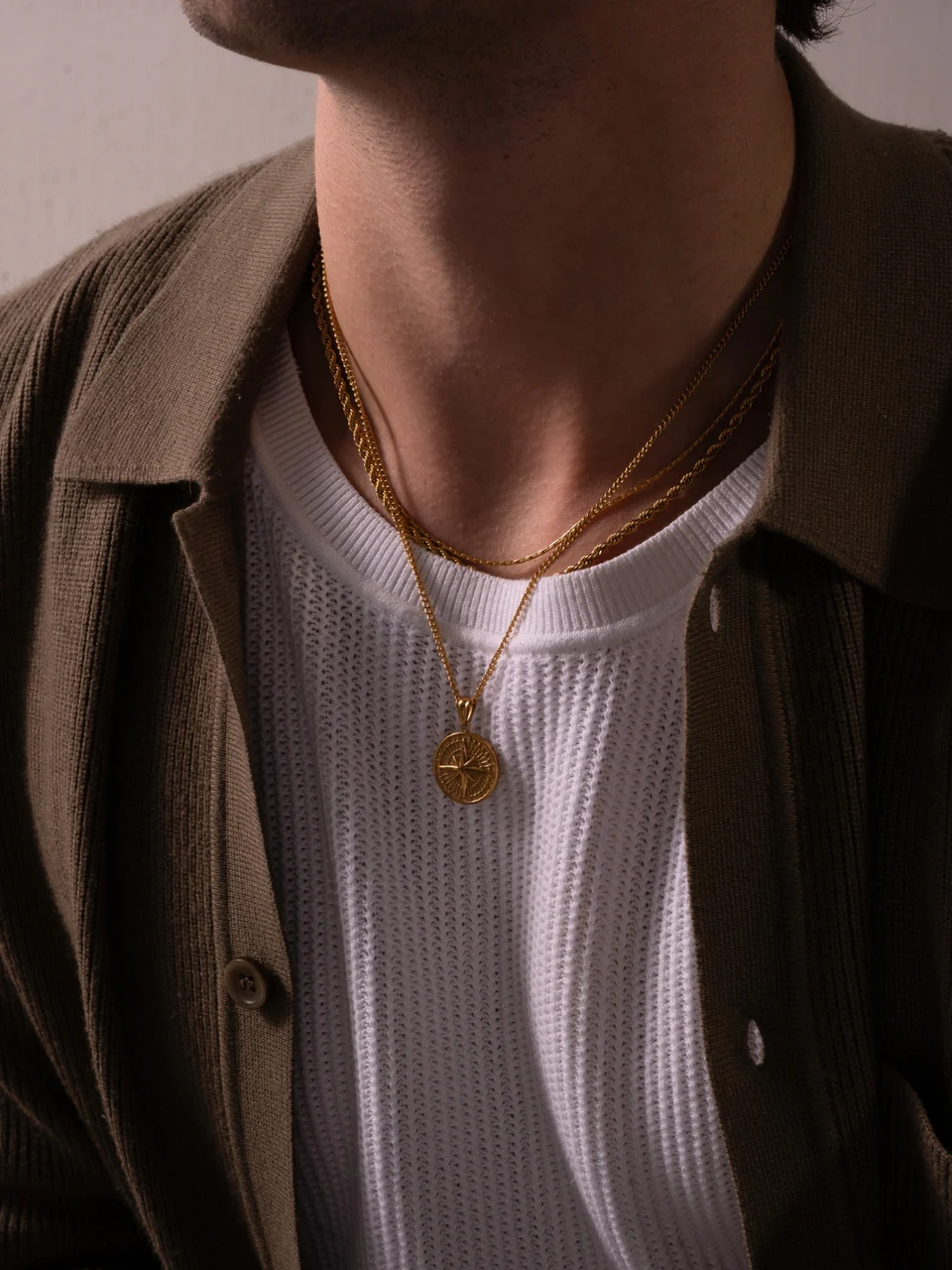 Collier en acier porté sous un polo sur la Riviera