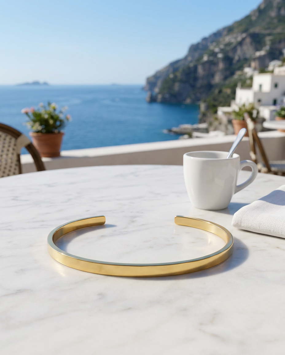 The Capri Slim Flat Bracelet su un tavolo di marmo con espresso e mare di Capri