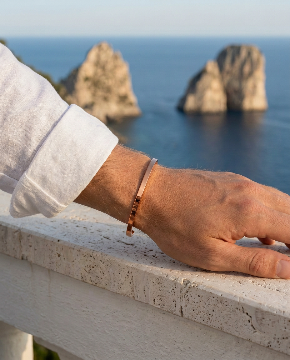 The Capri Slim Flat Bracelet al polso su una terrazza davanti ai Faraglioni