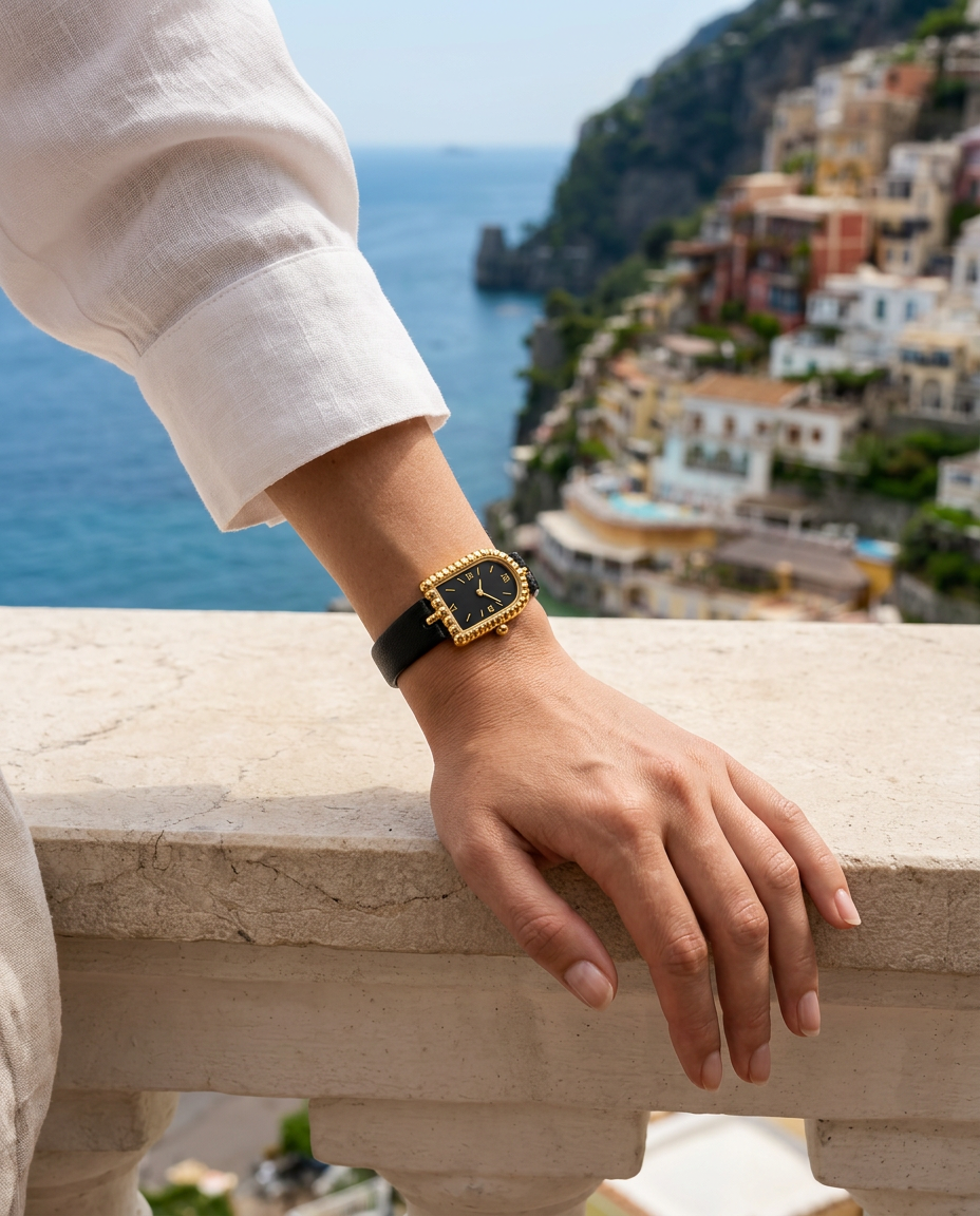 The Amalfi Black/Gold al polso di una donna in lino bianco sulla Costiera
