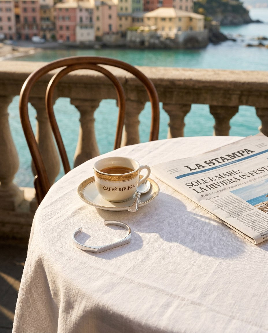 The Aura Signet Bracelet on a seaside café table with espresso